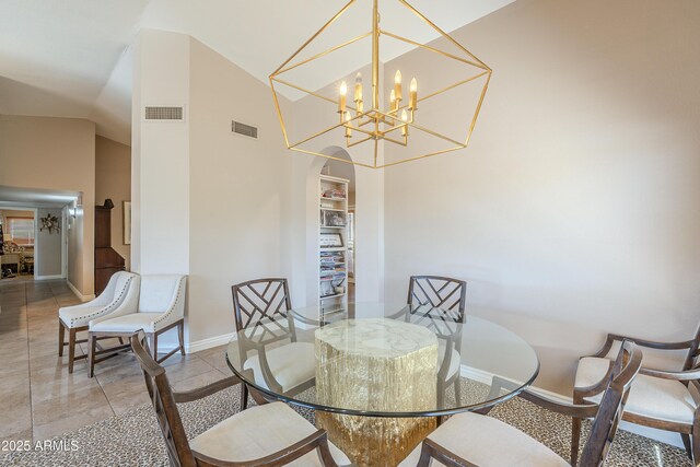 tiled dining space featuring lofted ceiling, arched walkways, visible vents, baseboards, and an inviting chandelier