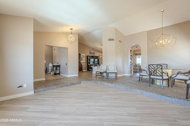 foyer entrance with high vaulted ceiling, baseboards, visible vents, and arched walkways