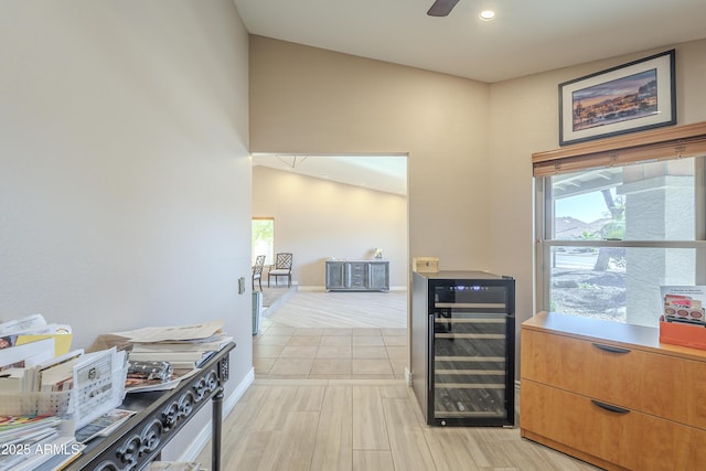 hallway with wine cooler, light wood-type flooring, and baseboards