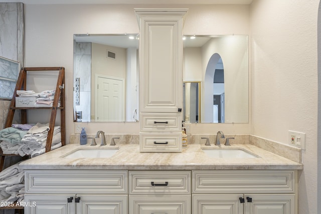 bathroom featuring double vanity, a sink, and visible vents