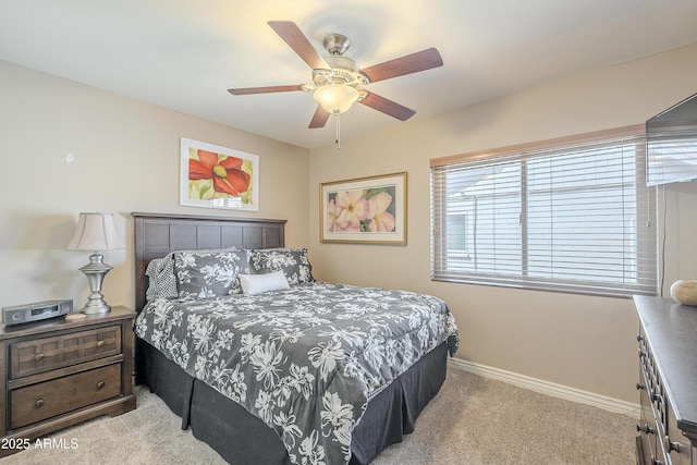 carpeted bedroom with ceiling fan and baseboards