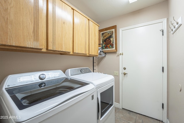laundry room featuring light tile patterned floors, cabinet space, and separate washer and dryer