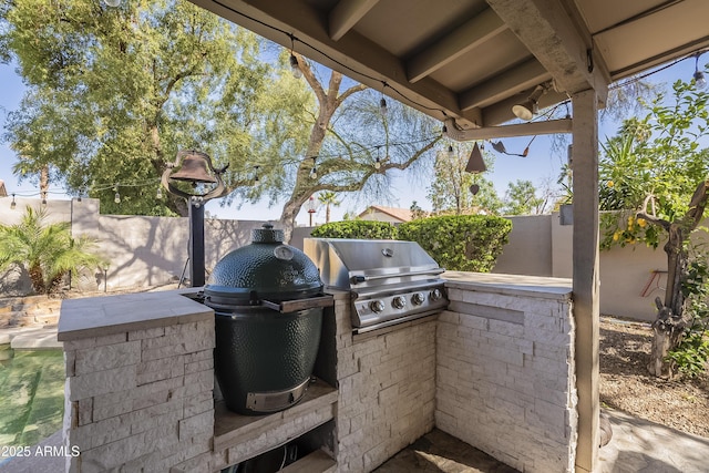 view of patio with a fenced backyard, exterior kitchen, and area for grilling