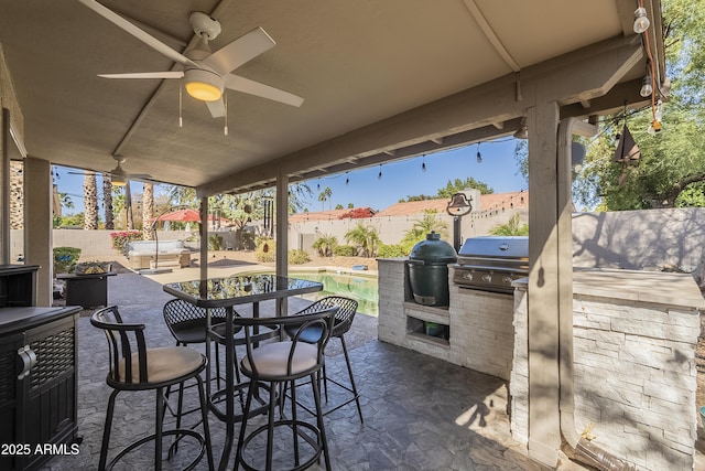 view of patio with a fenced backyard, grilling area, and exterior kitchen