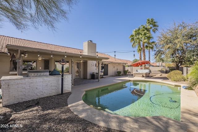 view of swimming pool featuring a patio, a ceiling fan, outdoor dry bar, exterior kitchen, and a fenced in pool