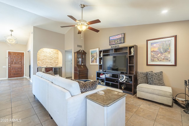 living area with light tile patterned floors, ceiling fan, high vaulted ceiling, and baseboards