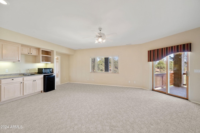 kitchen with light carpet, black appliances, plenty of natural light, and sink