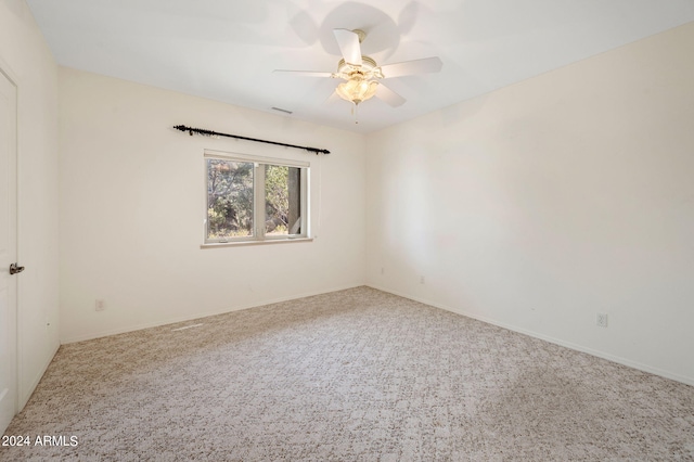 carpeted spare room featuring ceiling fan