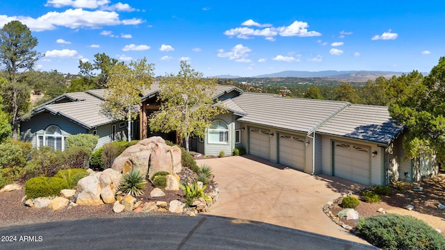 single story home with a mountain view and a garage