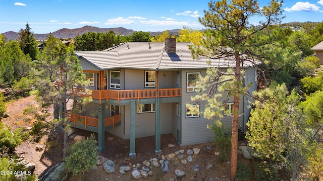 back of property with a balcony and a mountain view