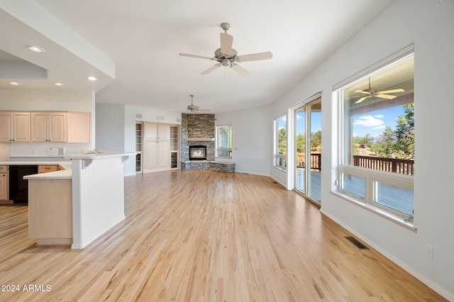 unfurnished living room with light wood-type flooring, ceiling fan, and a fireplace