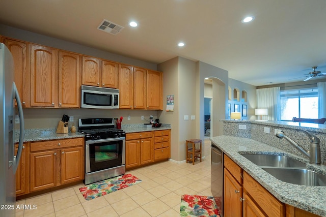 kitchen with arched walkways, visible vents, recessed lighting, appliances with stainless steel finishes, and a sink