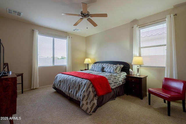 carpeted bedroom featuring visible vents, baseboards, and a ceiling fan