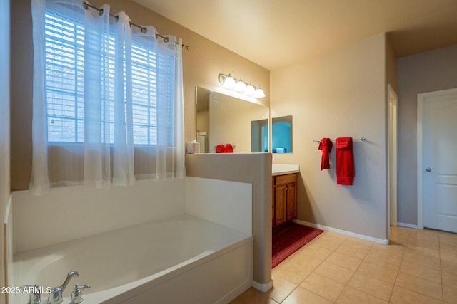 bathroom featuring tile patterned floors, vanity, baseboards, and a garden tub