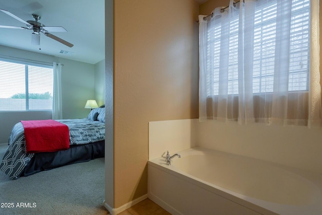 ensuite bathroom with ensuite bathroom, a bath, a ceiling fan, visible vents, and baseboards
