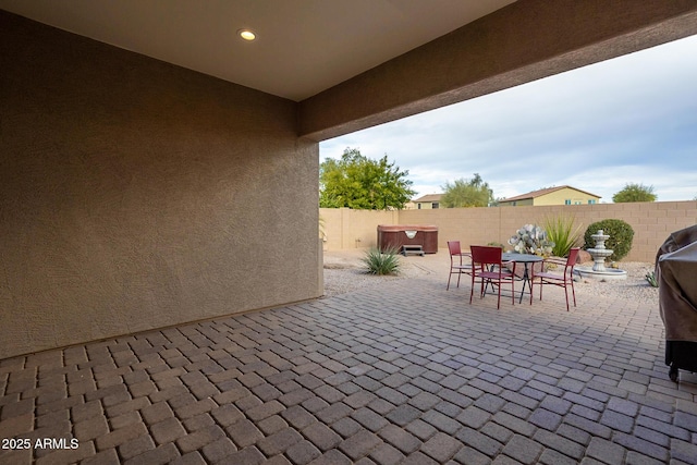 view of patio / terrace featuring a fenced backyard and a hot tub