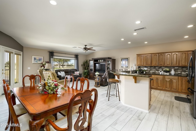 dining space with lofted ceiling, light hardwood / wood-style flooring, and ceiling fan