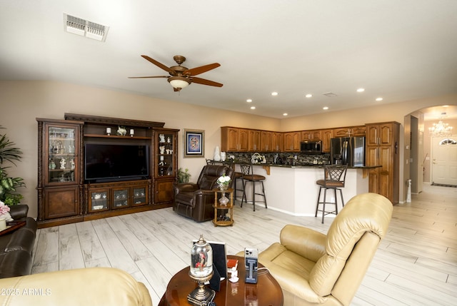 living room with ceiling fan and light hardwood / wood-style flooring