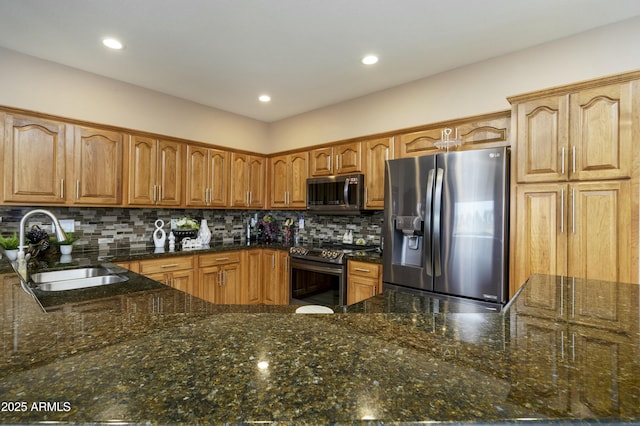 kitchen with appliances with stainless steel finishes, sink, and dark stone counters