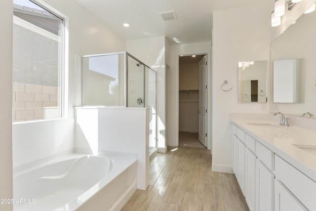 bathroom featuring separate shower and tub, a wealth of natural light, hardwood / wood-style floors, and vanity