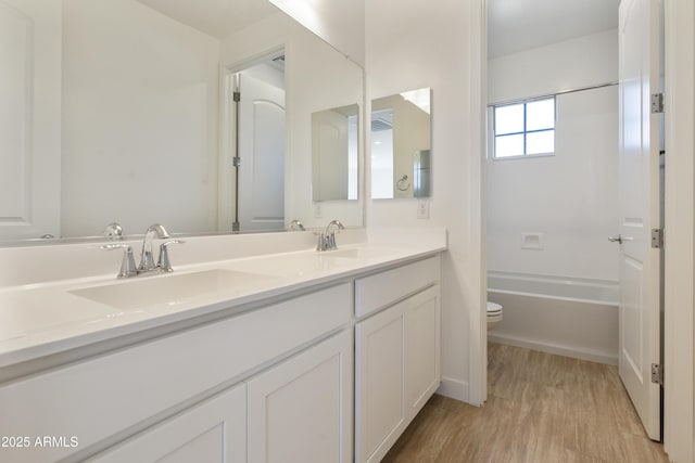 full bathroom featuring hardwood / wood-style flooring, vanity, toilet, and bathtub / shower combination