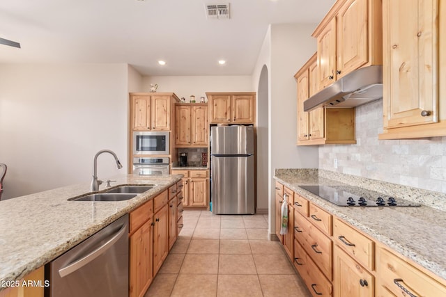 kitchen with backsplash, light stone counters, stainless steel appliances, sink, and light tile patterned floors