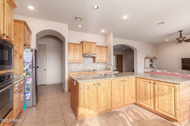 kitchen with light brown cabinets, sink, ceiling fan, light stone countertops, and stainless steel appliances