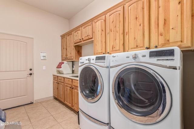 laundry room featuring cabinets, light tile patterned floors, and separate washer and dryer