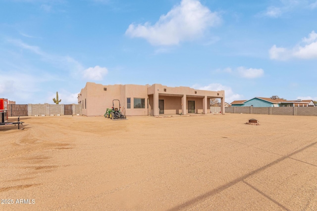 rear view of house with an outdoor fire pit