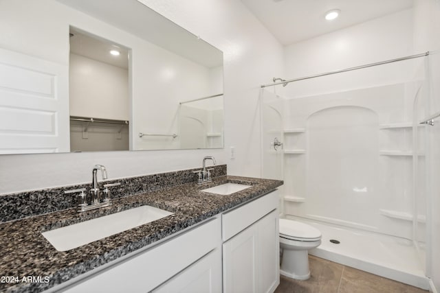 bathroom featuring a shower stall, toilet, tile patterned flooring, double vanity, and recessed lighting
