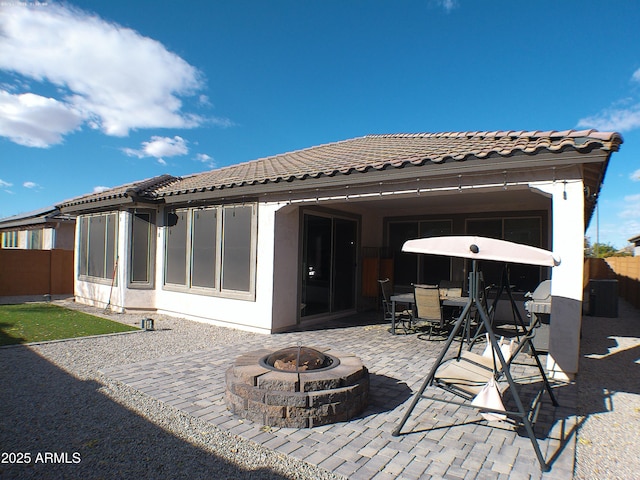 back of house featuring a fire pit and a patio