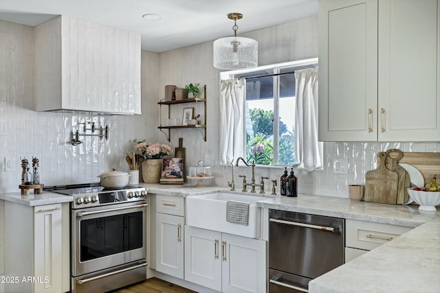 kitchen featuring light stone countertops, a sink, decorative backsplash, hanging light fixtures, and appliances with stainless steel finishes