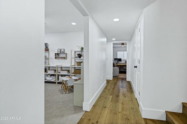 hall with baseboards, light wood-type flooring, and recessed lighting