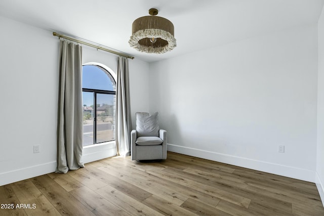 unfurnished room with baseboards and wood finished floors