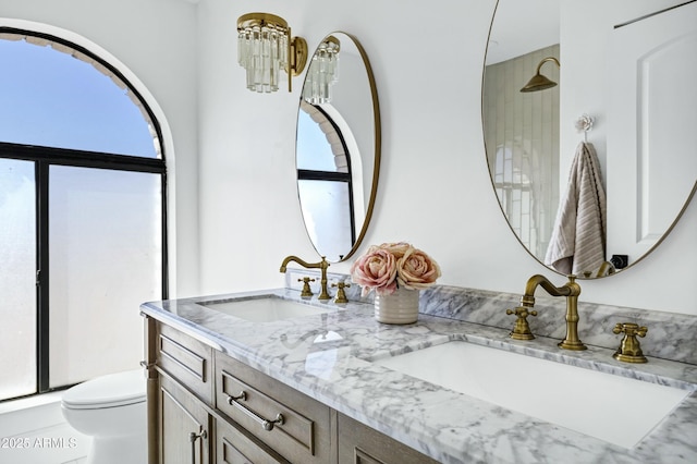 bathroom featuring plenty of natural light, toilet, and a sink