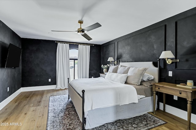 bedroom with baseboards, ceiling fan, and light wood-style flooring
