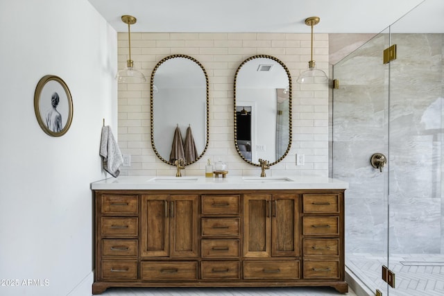 bathroom with double vanity, visible vents, a shower stall, and a sink