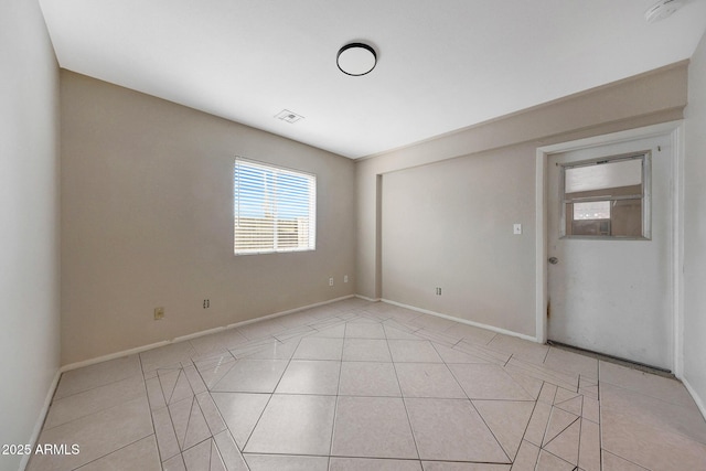 unfurnished room with visible vents, baseboards, and light tile patterned floors