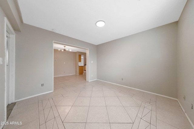 spare room with baseboards, an inviting chandelier, and light tile patterned floors