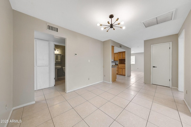 unfurnished room with light tile patterned floors, baseboards, visible vents, and a notable chandelier