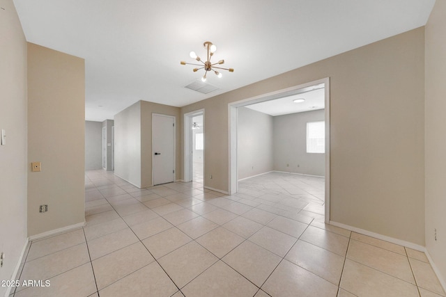 spare room with light tile patterned floors, baseboards, visible vents, and a notable chandelier