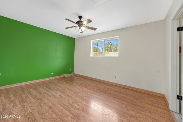 empty room with a ceiling fan, baseboards, and light wood finished floors