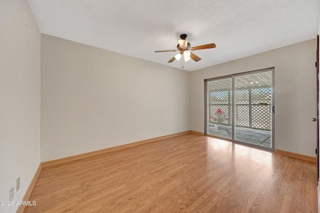 spare room with light wood-style floors, ceiling fan, baseboards, and a textured ceiling