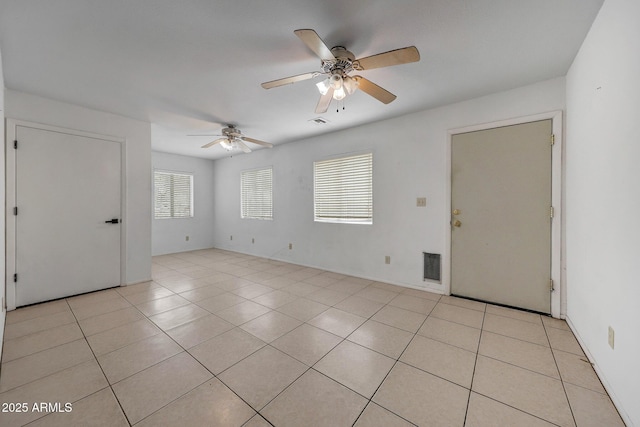 empty room with light tile patterned floors, ceiling fan, and visible vents