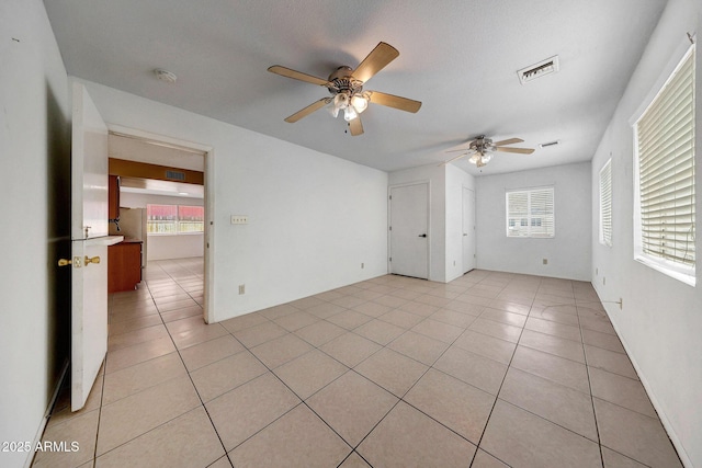 spare room with visible vents, ceiling fan, and light tile patterned floors