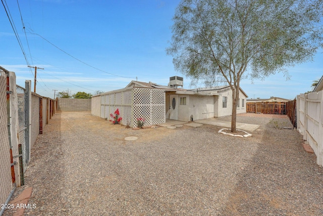 rear view of house with central air condition unit, a patio area, a fenced backyard, and stucco siding