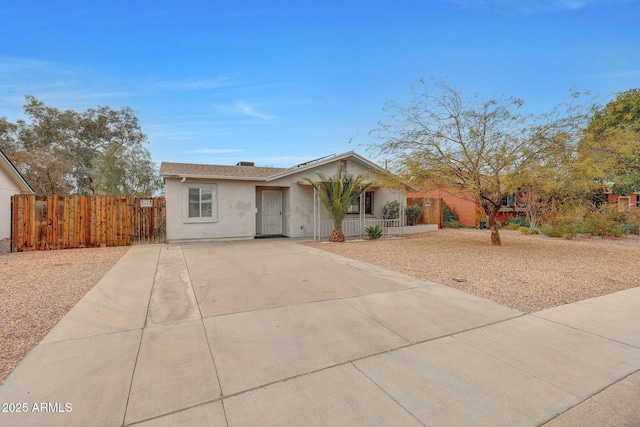 view of front facade featuring covered porch, fence, and stucco siding