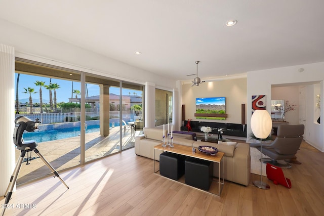 living room with ceiling fan and light hardwood / wood-style flooring