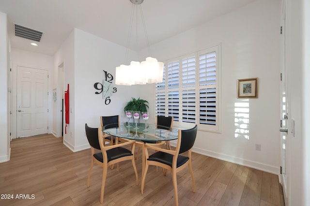 dining area featuring light hardwood / wood-style flooring and an inviting chandelier