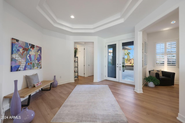 foyer featuring a raised ceiling, french doors, and wood-type flooring